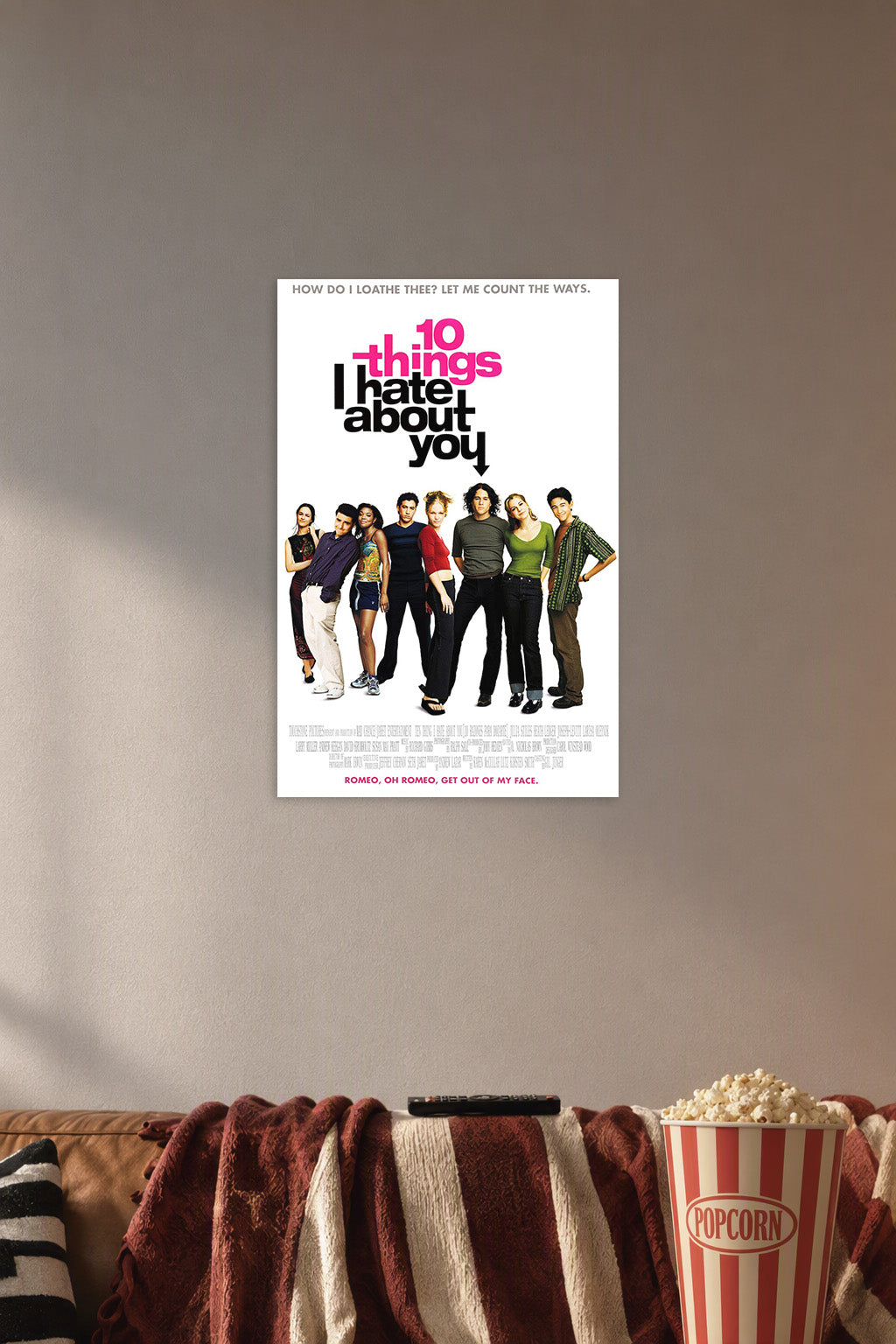 10 Things I Hate About You movie poster in a cozy movie room above a brown sofa with popcorn.