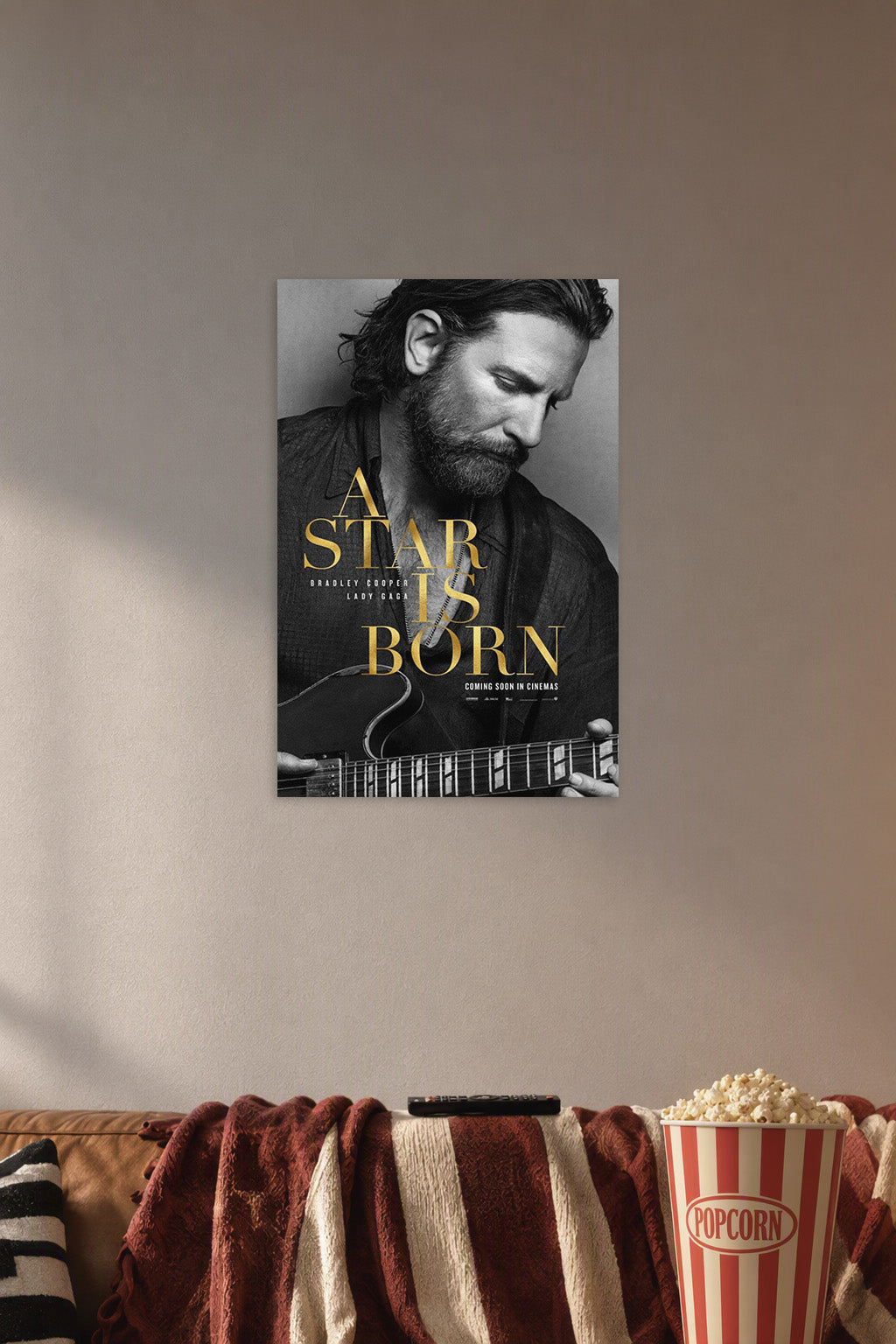 A Star Is Born Bradley Cooper in a cozy movie room above a brown sofa with popcorn.