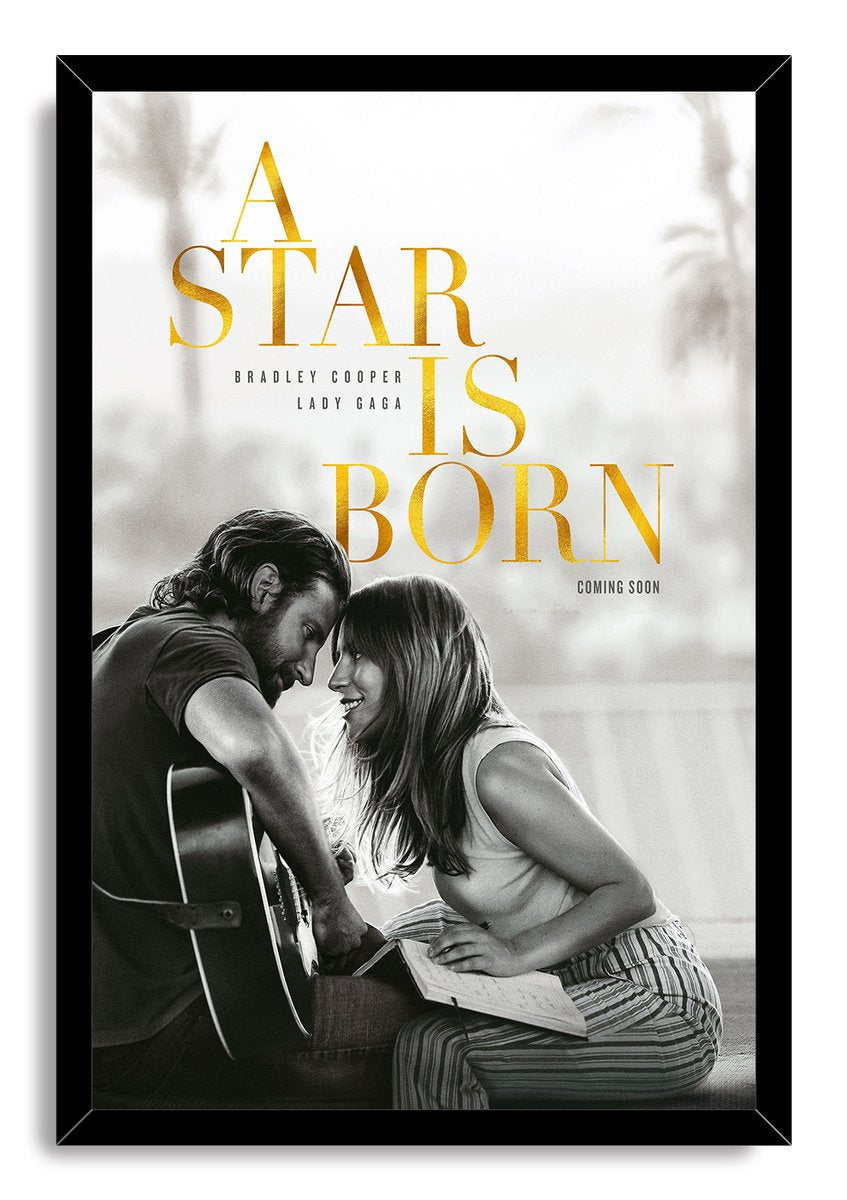 A Star Is Born framed wall art print in a black border, with gold title text and a grayscale couple beside a guitar.