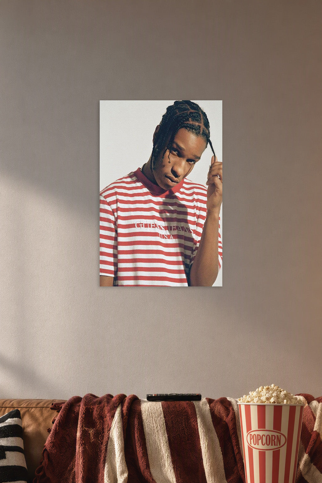 A$AP Rocky in a cozy movie room above a brown sofa with popcorn.