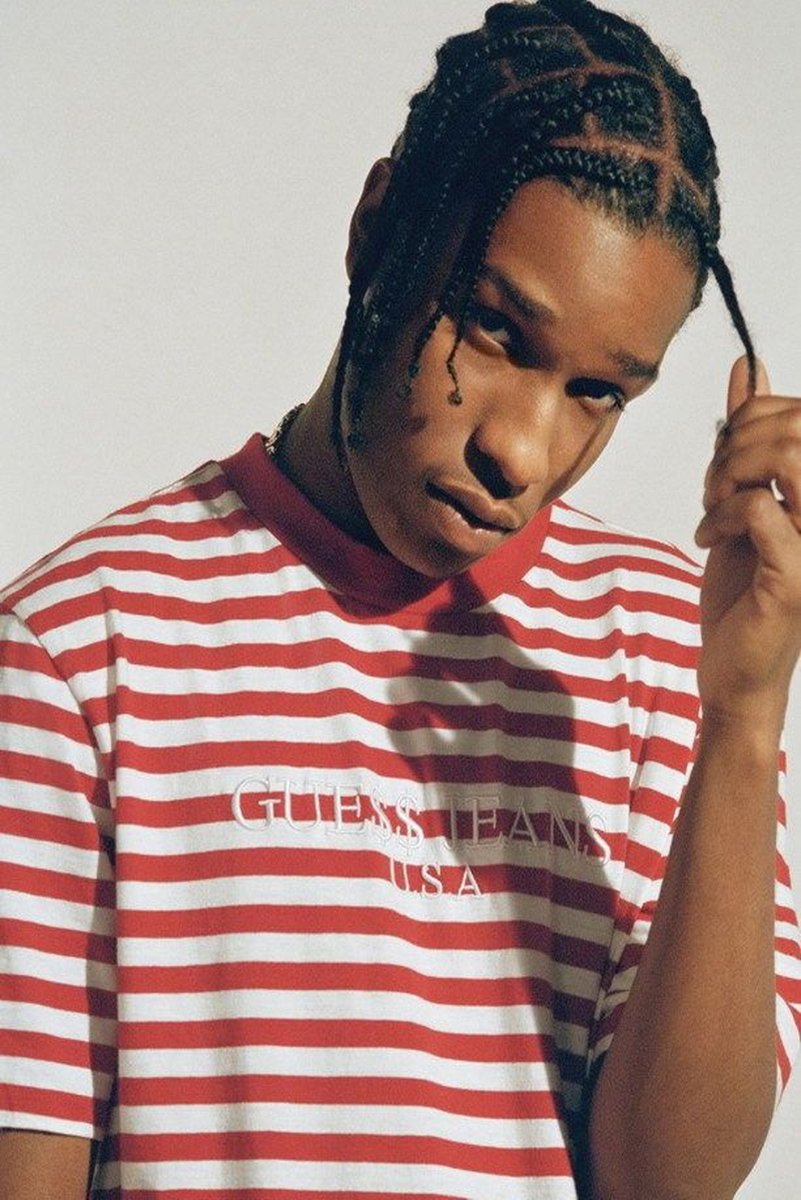 A$AP Rocky poster portrait in a red and white striped Guess Jeans shirt, holding a braid against a pale background.