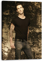 Adam Levine canvas wall art print features a full-length portrait in black clothing, with tattooed arms and a textured sepia backdrop.