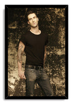 Adam Levine framed wall art print presents his black T-shirt and jeans portrait within a glossy black mitered frame.
