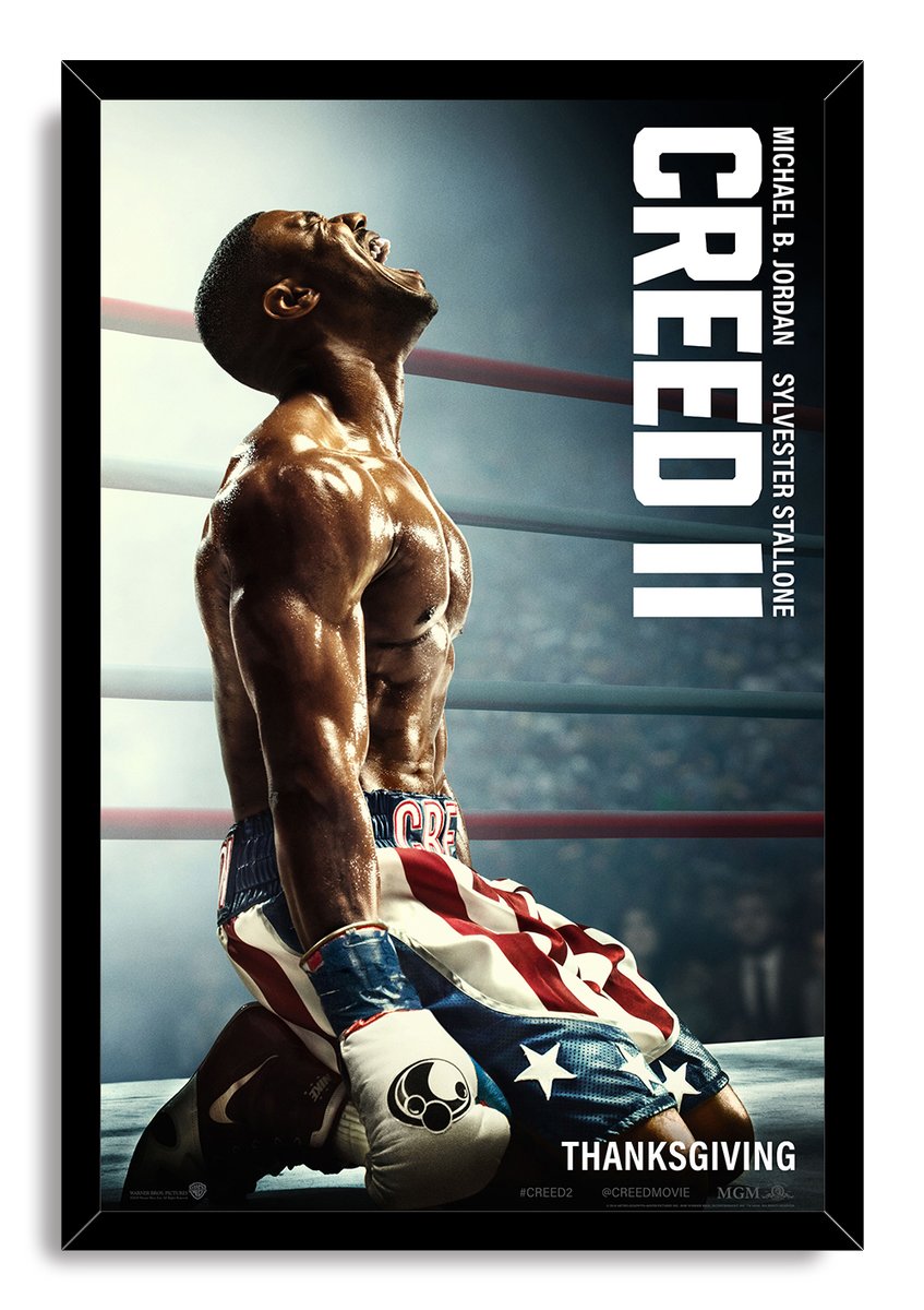 Creed II framed wall art print of Adonis Creed on one knee in American flag boxing trunks, surrounded by a black frame.