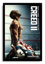 Creed II framed wall art print of Adonis Creed on one knee in American flag boxing trunks, surrounded by a black frame.