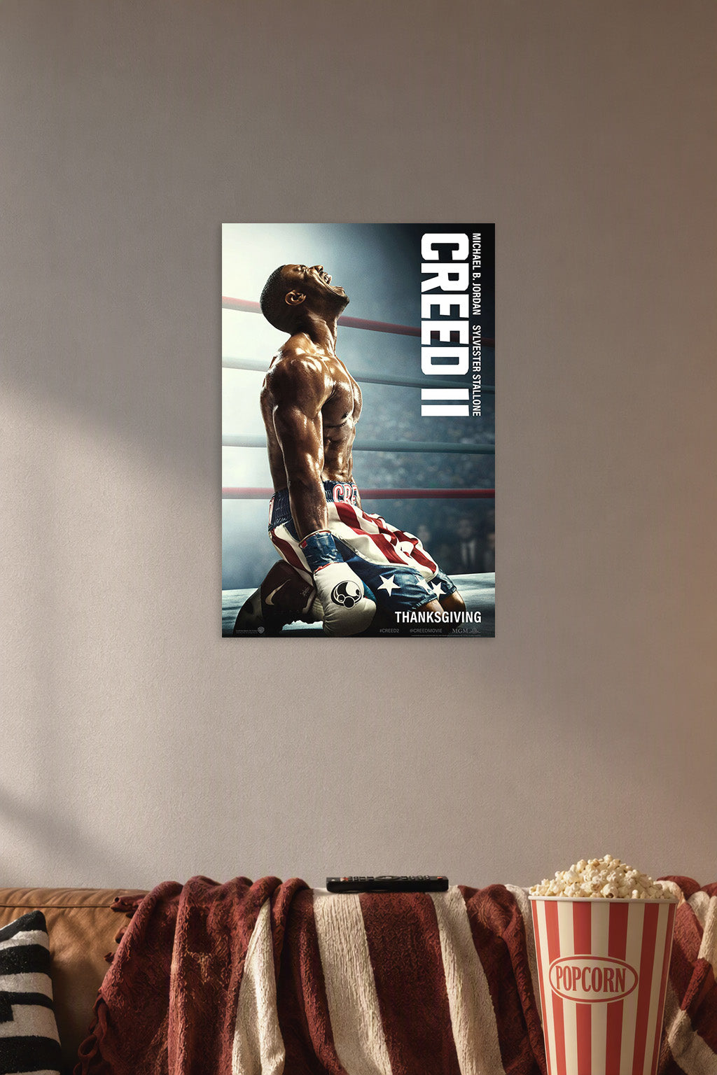 Adonis Creed Michael B. Jordan Creed II Movie in a cozy movie room above a brown sofa with popcorn.
