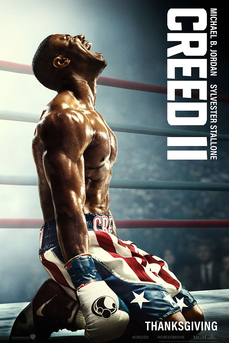 Creed II movie poster wall art print of Adonis Creed kneeling in a boxing ring in red, white, and blue trunks and gloves.