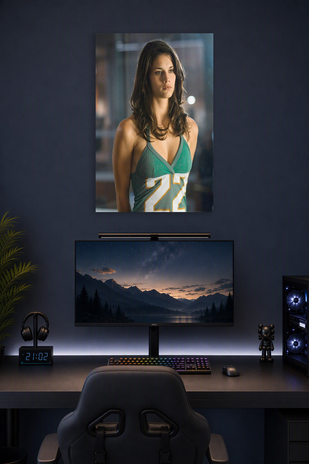 Adrianne Palicki in a gaming desk setup above a monitor.