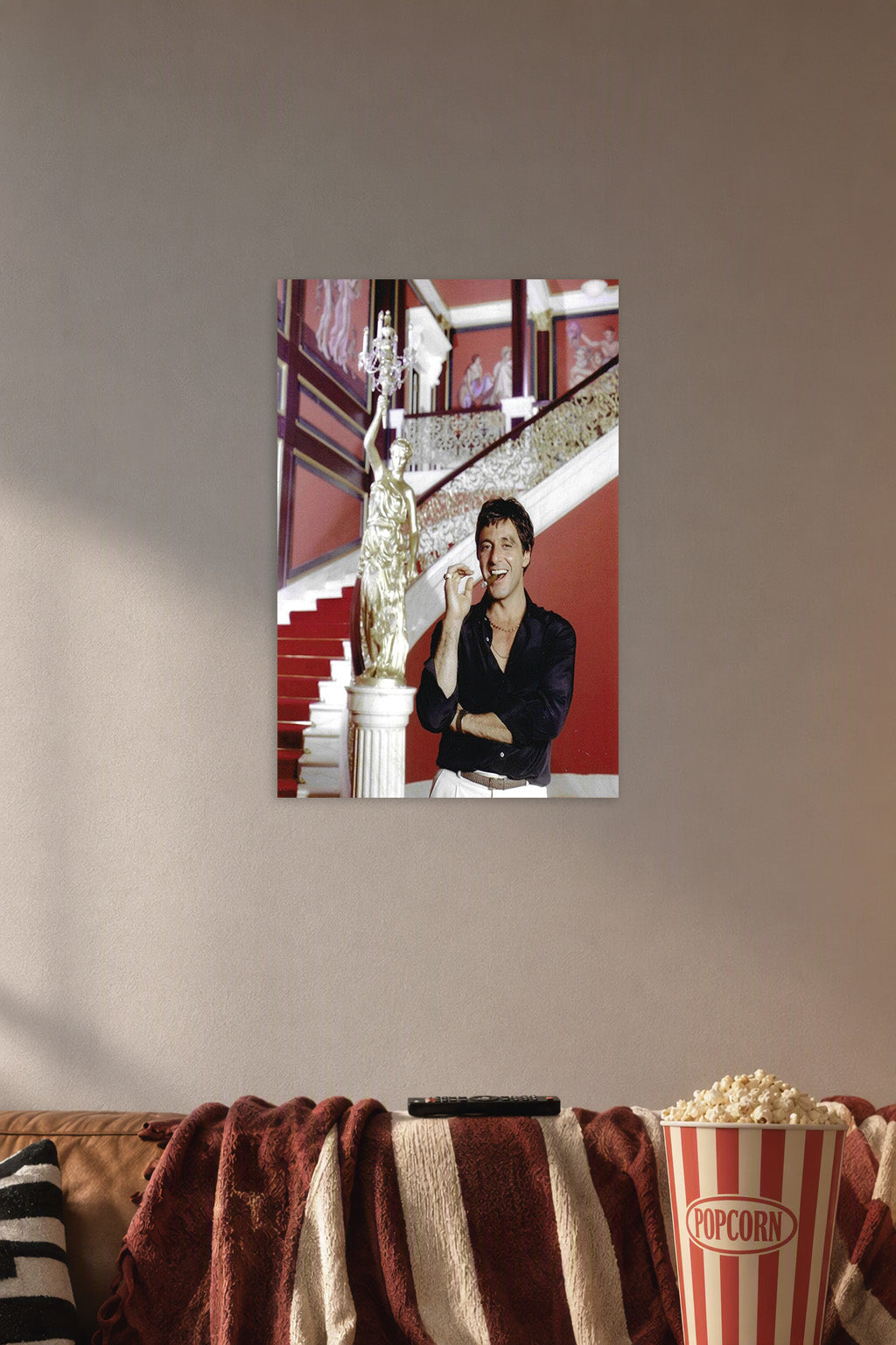 Al Pacino Scarface Tony Montana in a cozy movie room above a brown sofa with popcorn.