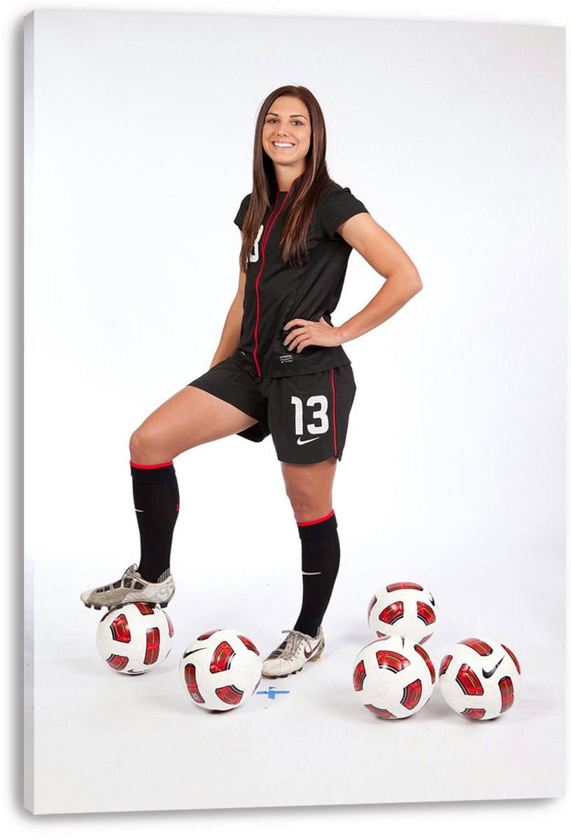 Alex Morgan canvas wall art print displays a soccer player in a black number 13 uniform with one foot on a ball.