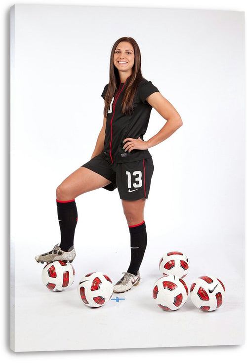 Alex Morgan canvas wall art print displays a soccer player in a black number 13 uniform with one foot on a ball.
