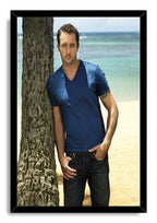 Alex O'Loughlin framed wall art print presents the actor in dark jeans and a blue shirt against a tropical shoreline.