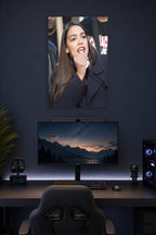 Alexandria Ocasio-Cortez in a gaming desk setup above a monitor.