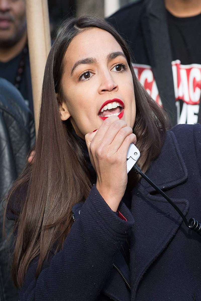 Alexandria Ocasio-Cortez poster features a close-up of her speaking into a white handheld microphone in a crowd.