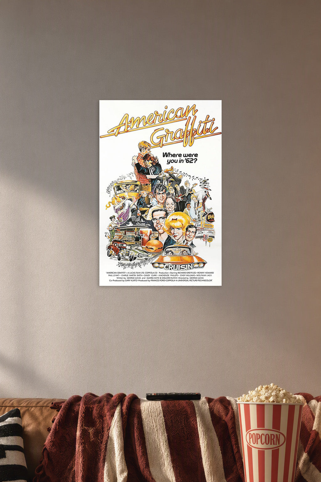 American Graffiti Movie Poster in a cozy movie room above a brown sofa with popcorn.