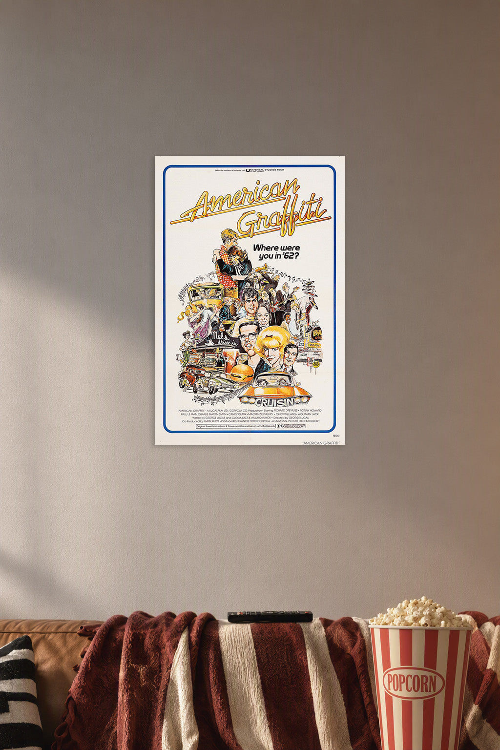 American Graffiti Movie Poster in a cozy movie room above a brown sofa with popcorn.