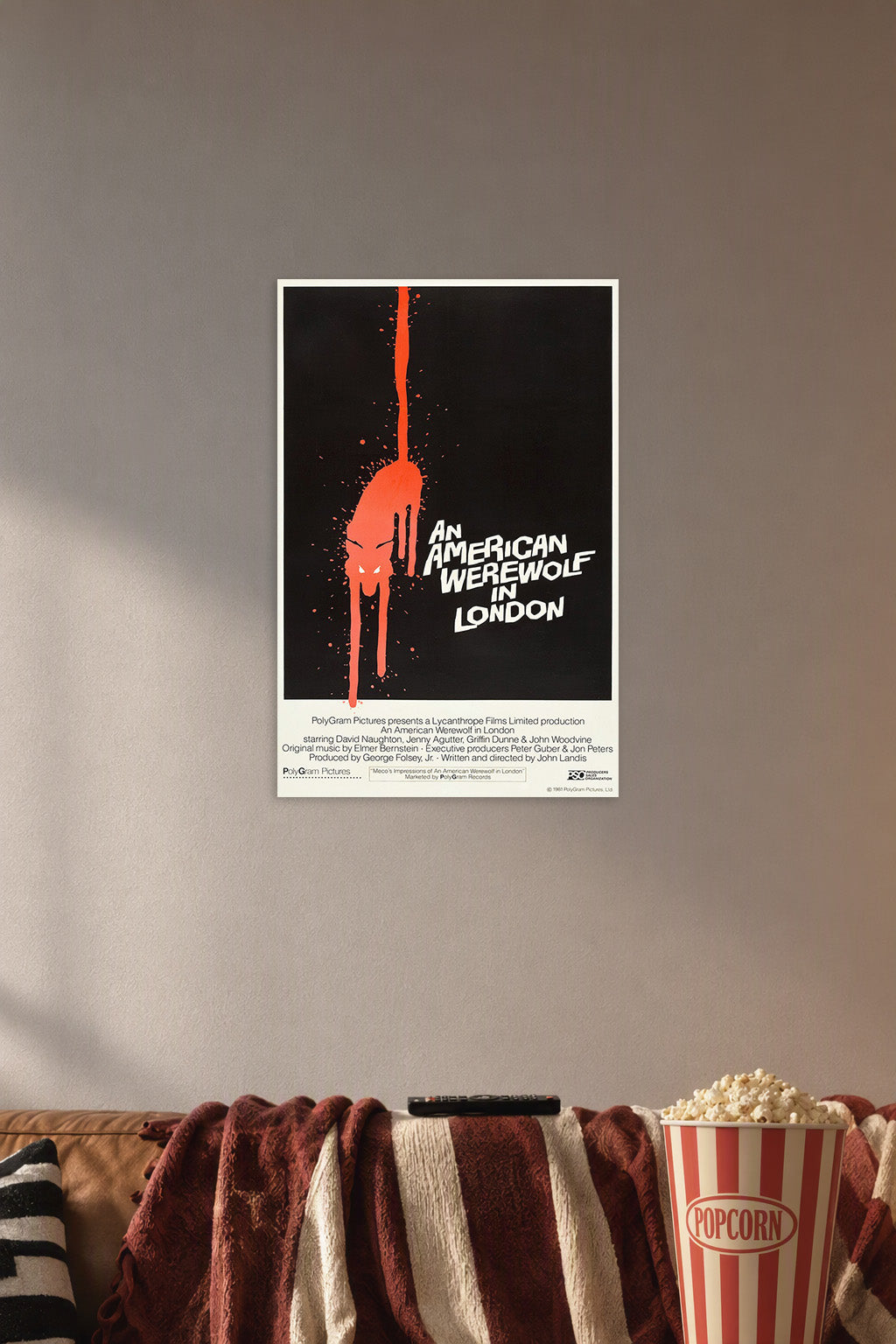 An American Werewolf in London Movie Poster in a cozy movie room above a brown sofa with popcorn.
