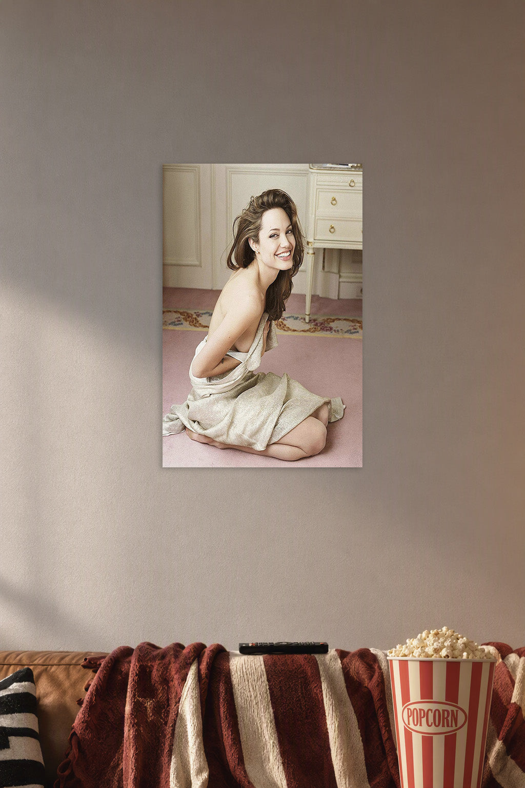 Angelina Jolie in a cozy movie room above a brown sofa with popcorn.