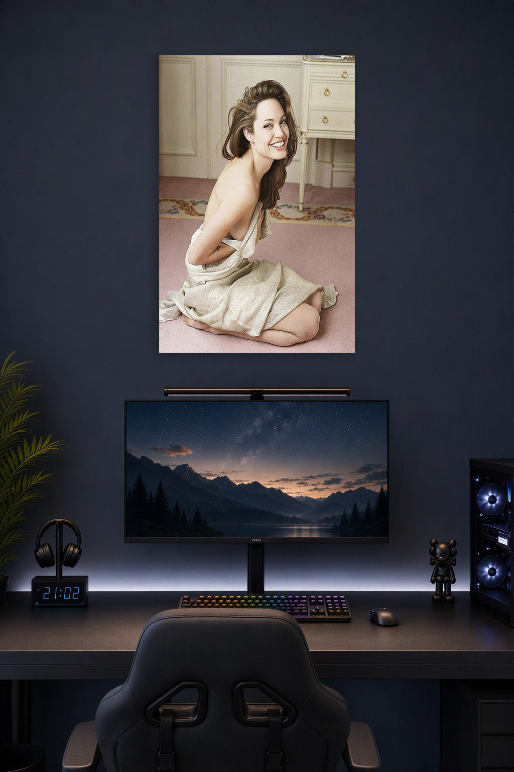 Angelina Jolie in a gaming desk setup above a monitor.