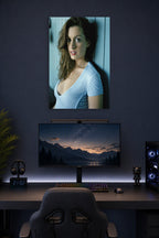 Anne Hathaway in a gaming desk setup above a monitor.
