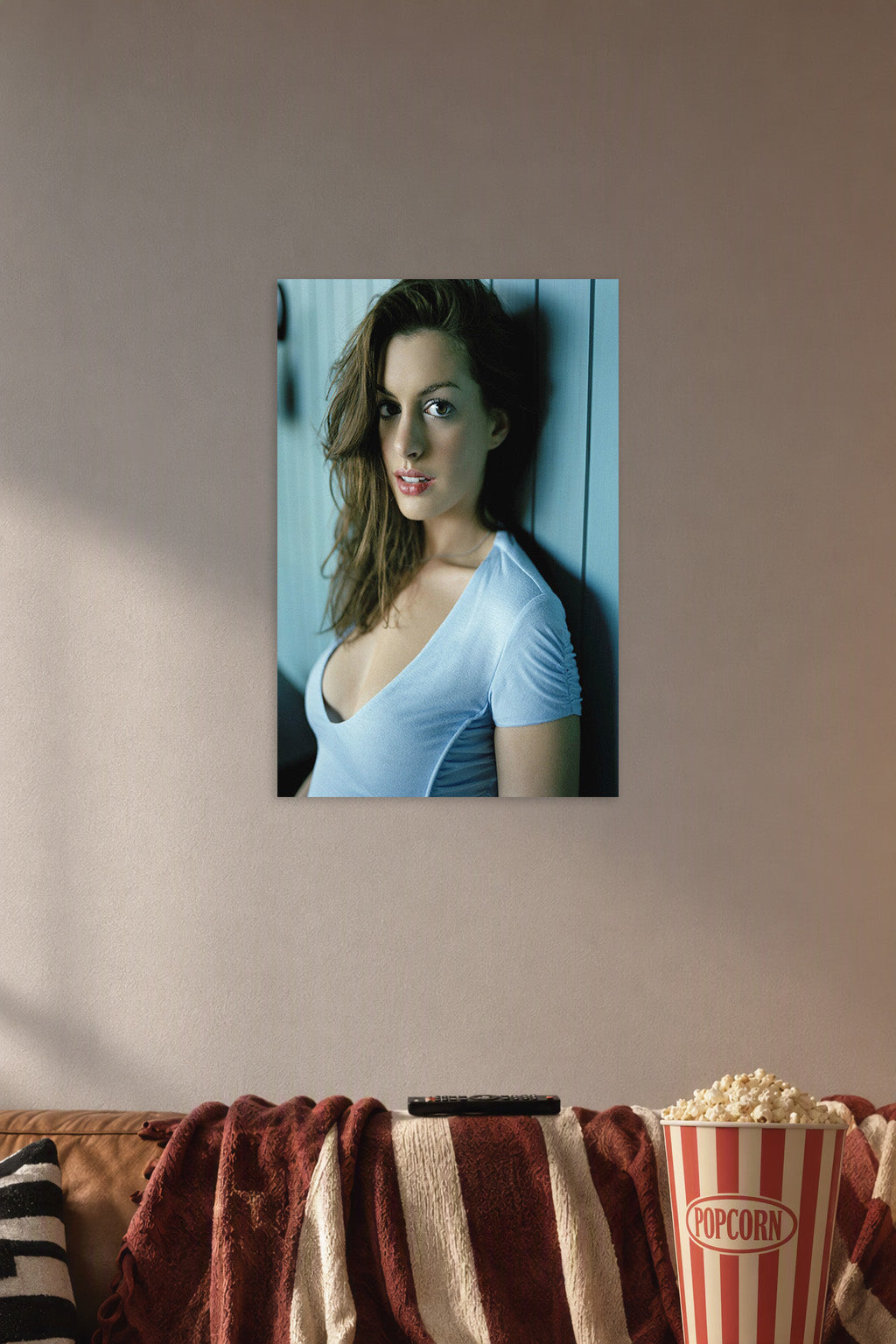 Anne Hathaway in a cozy movie room above a brown sofa with popcorn.