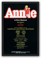Annie framed wall art print with a black border, large red-outlined white title, curly-haired girl, and theater billing text.