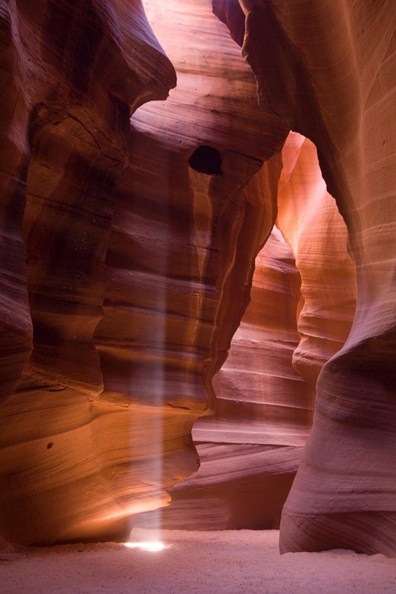 Antelope Canyon wall art print featuring sculpted red and orange sandstone walls lit by a narrow sunbeam.