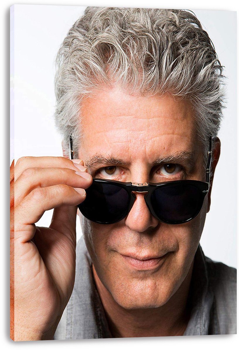 Anthony Bourdain canvas wall art print featuring a close-up portrait as he lowers black sunglasses beneath his gaze.