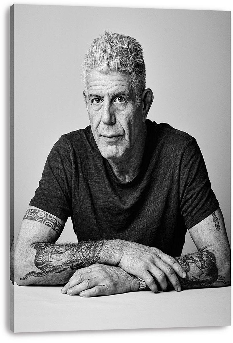 Anthony Bourdain canvas wall art print presents a monochrome portrait of the chef in a dark T-shirt, hands resting on a table.