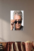 Anthony Bourdain in a cozy movie room above a brown sofa with popcorn.