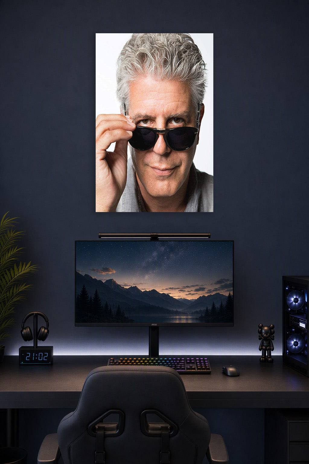 Anthony Bourdain in a gaming desk setup above a monitor.