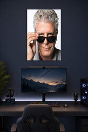 Anthony Bourdain in a gaming desk setup above a monitor.