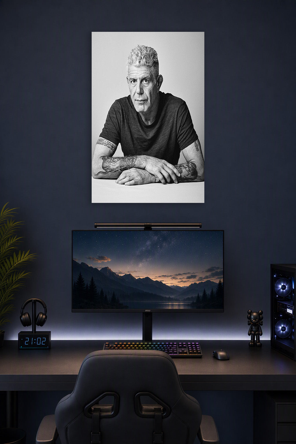 Anthony Bourdain in a gaming desk setup above a monitor.
