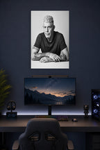 Anthony Bourdain in a gaming desk setup above a monitor.