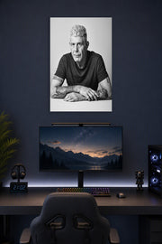 Anthony Bourdain in a gaming desk setup above a monitor.