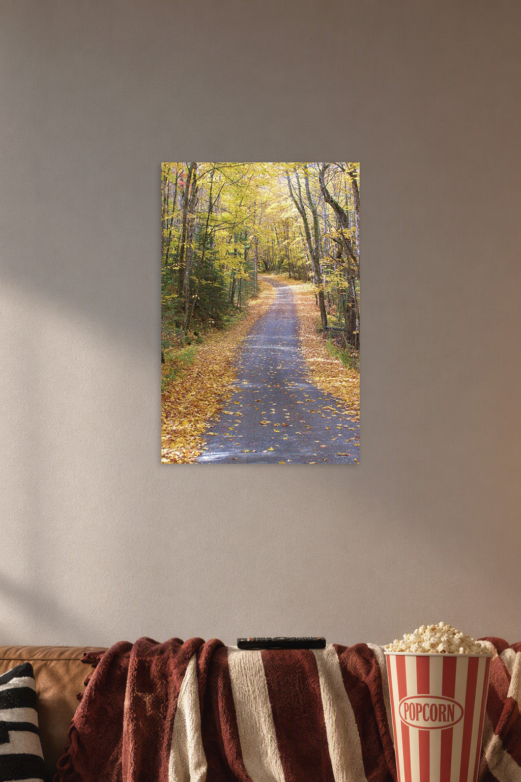 Autumn Forest Path in a cozy movie room above a brown sofa with popcorn.