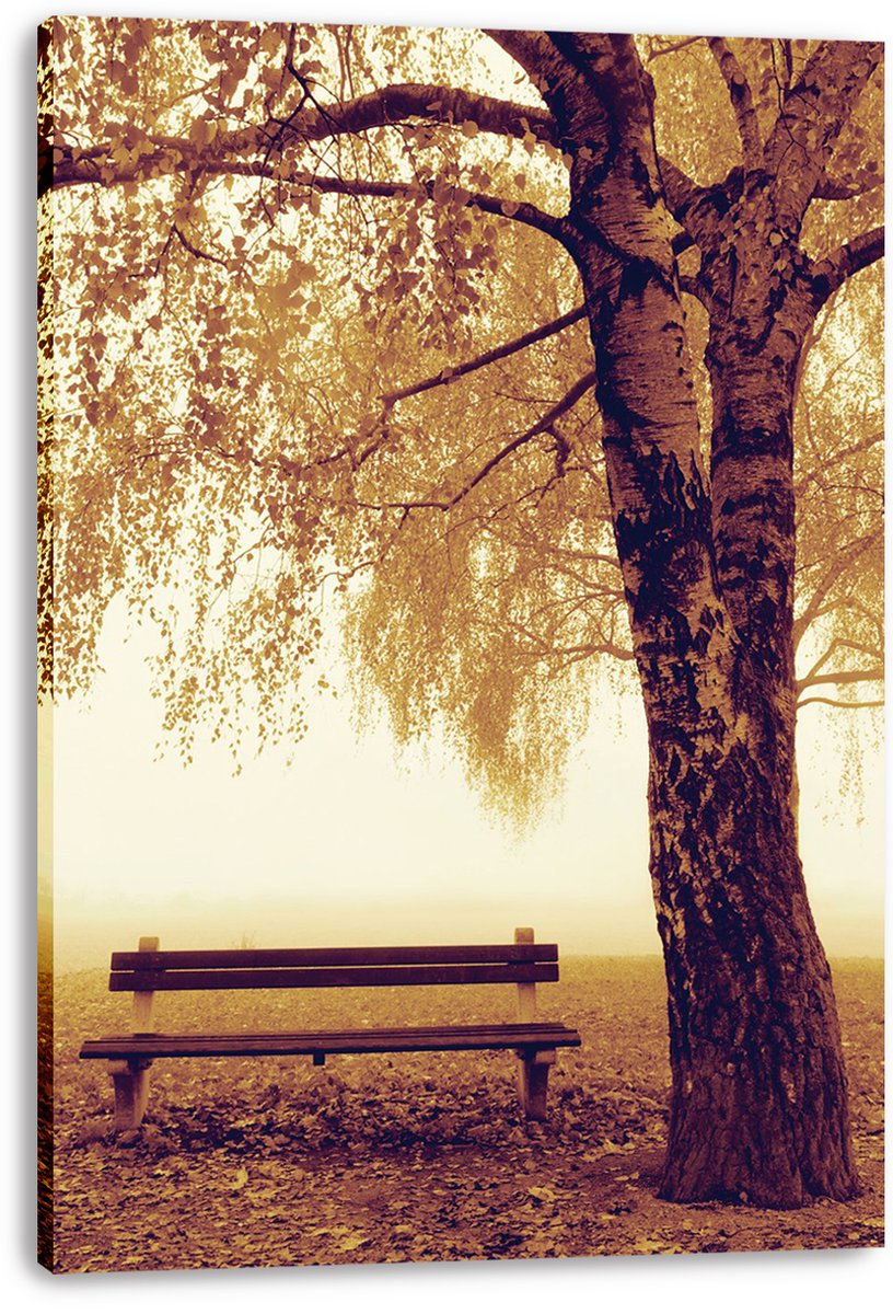 Autumn park bench canvas print featuring a dark tree trunk, hanging golden foliage, and a quiet misty landscape.