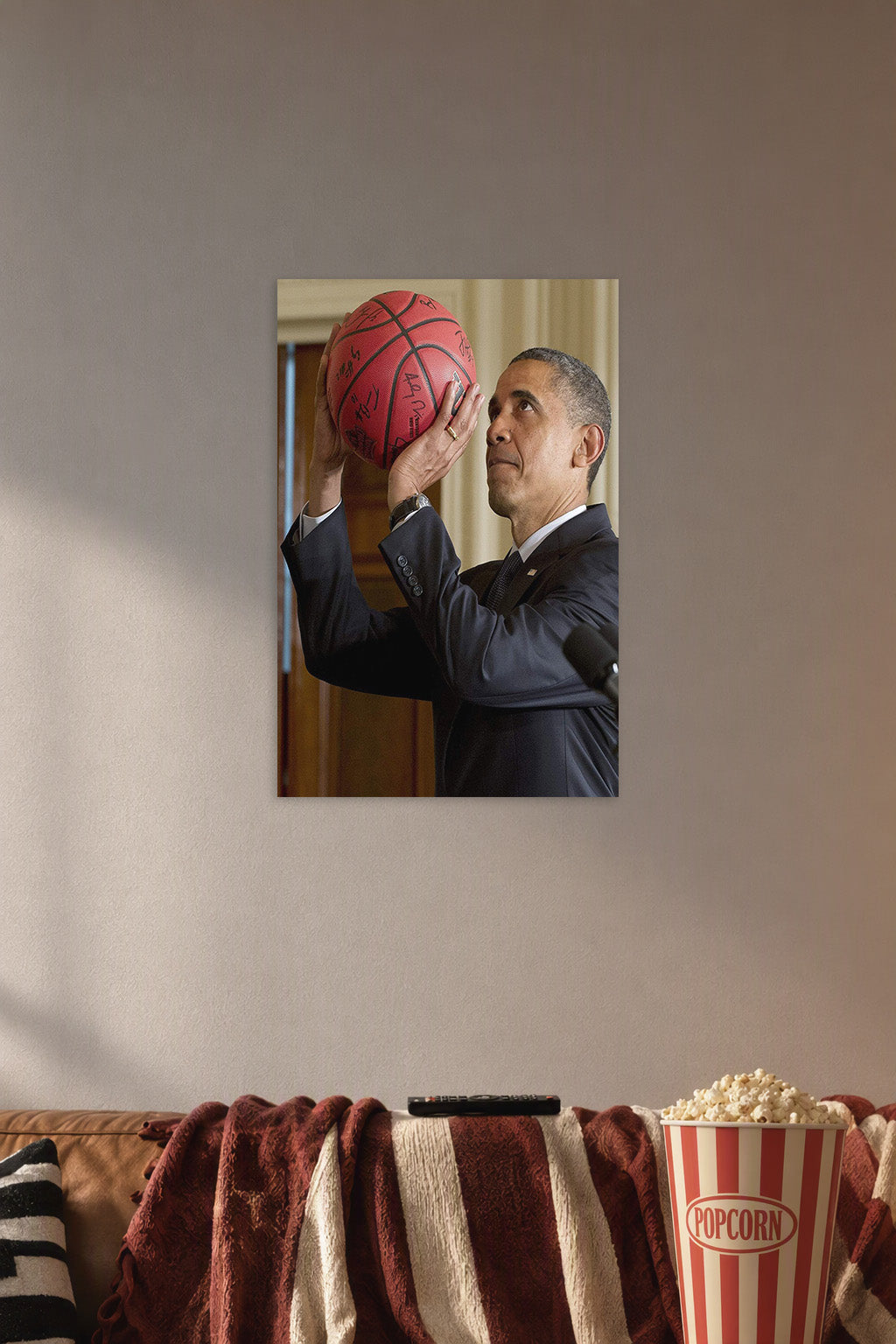 Barack Obama Basketball in a cozy movie room above a brown sofa with popcorn.