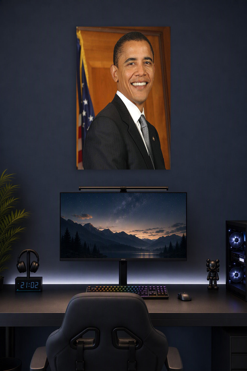 Barack Obama in a gaming desk setup above a monitor.