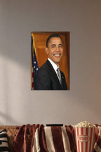 Barack Obama in a cozy movie room above a brown sofa with popcorn.