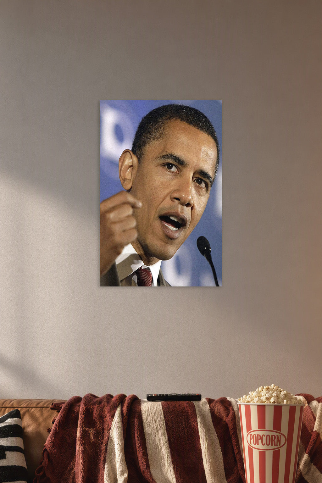 Barack Obama in a cozy movie room above a brown sofa with popcorn.