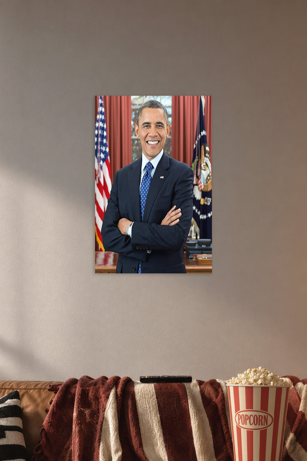 Barack Obama in a cozy movie room above a brown sofa with popcorn.
