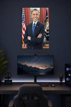 Barack Obama in a gaming desk setup above a monitor.