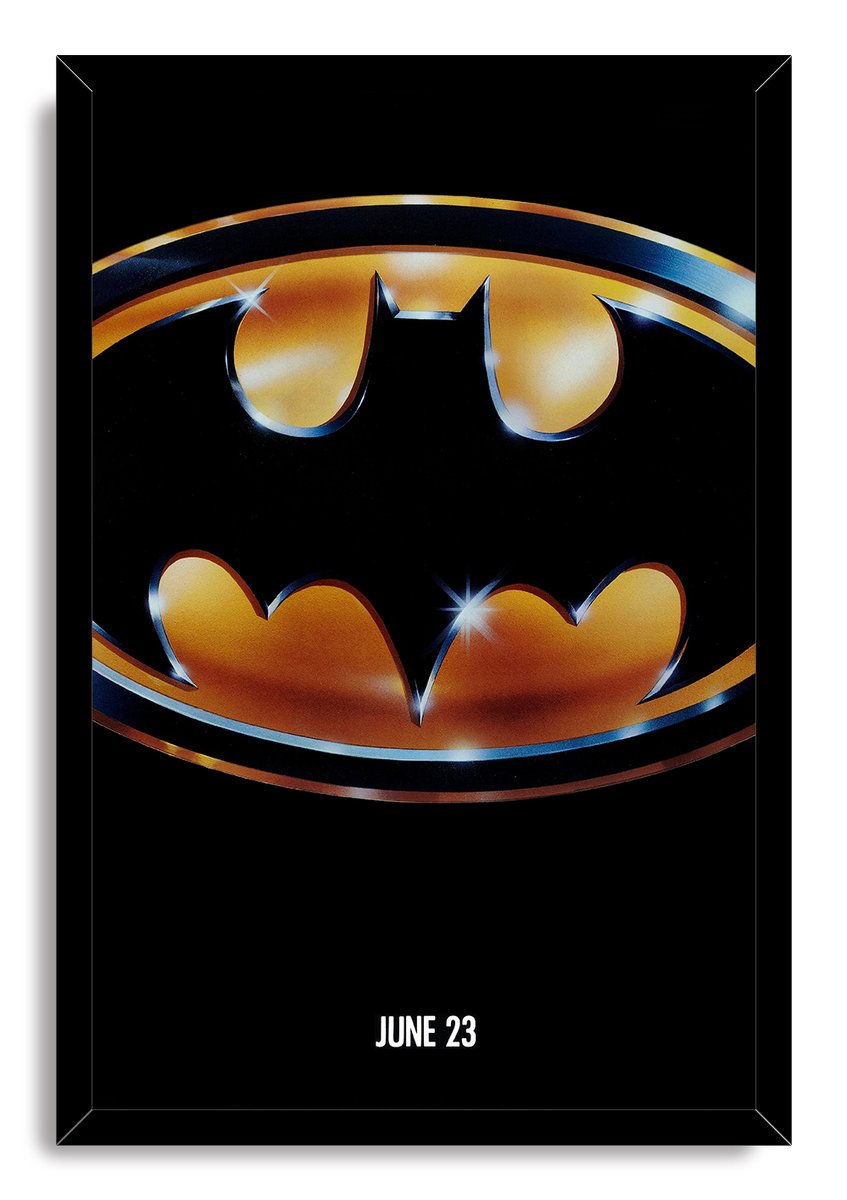 Batman framed wall art print with a gold-and-black bat emblem, star-like reflections, black border, and “JUNE 23” text.