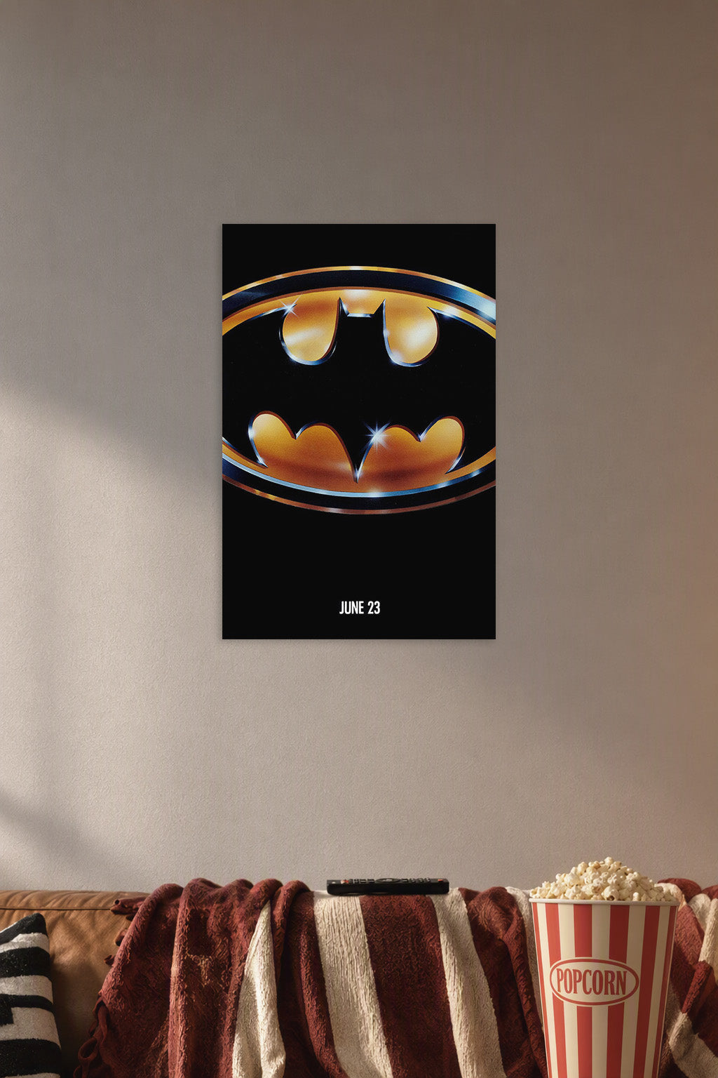 Batman Logo in a cozy movie room above a brown sofa with popcorn.