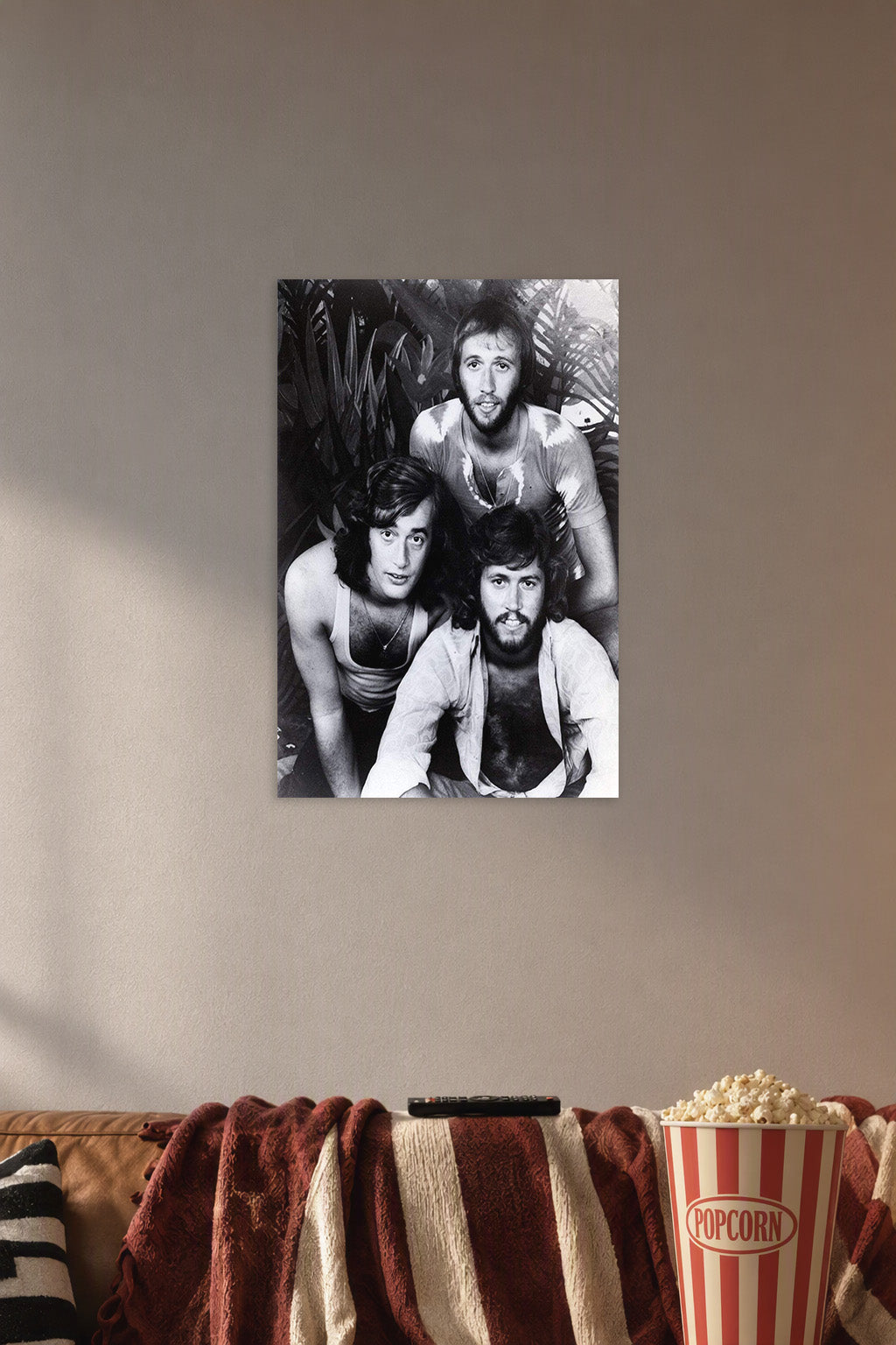 Bee Gees in a cozy movie room above a brown sofa with popcorn.