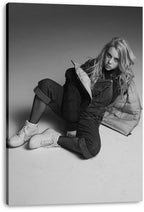 Billie Eilish canvas wall art print presents a grayscale seated portrait with long hair, layered streetwear, fishnet tights, and white sneakers.