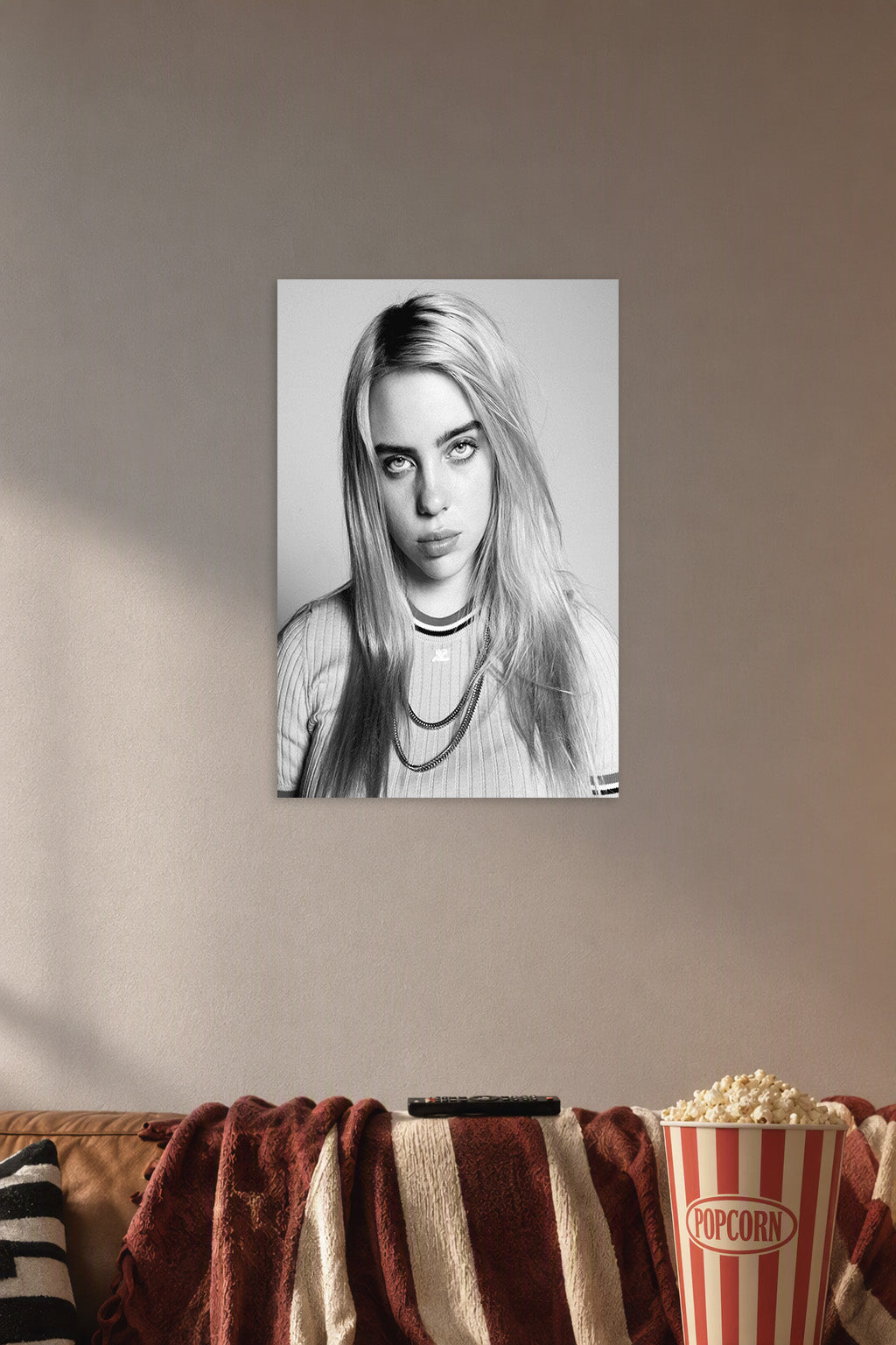 Billie Eilish in a cozy movie room above a brown sofa with popcorn.