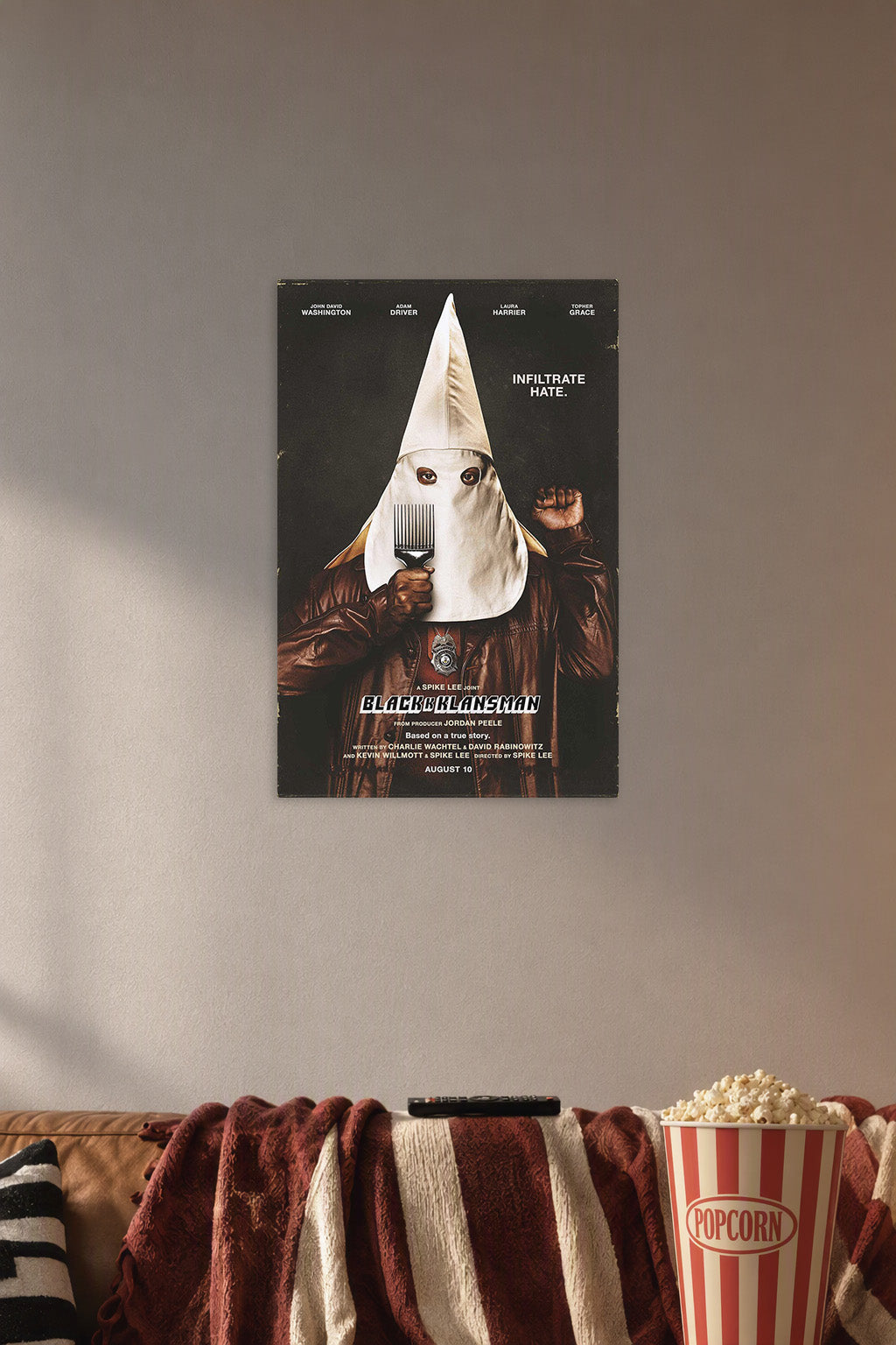 BlacKkKlansman Movie Poster in a cozy movie room above a brown sofa with popcorn.