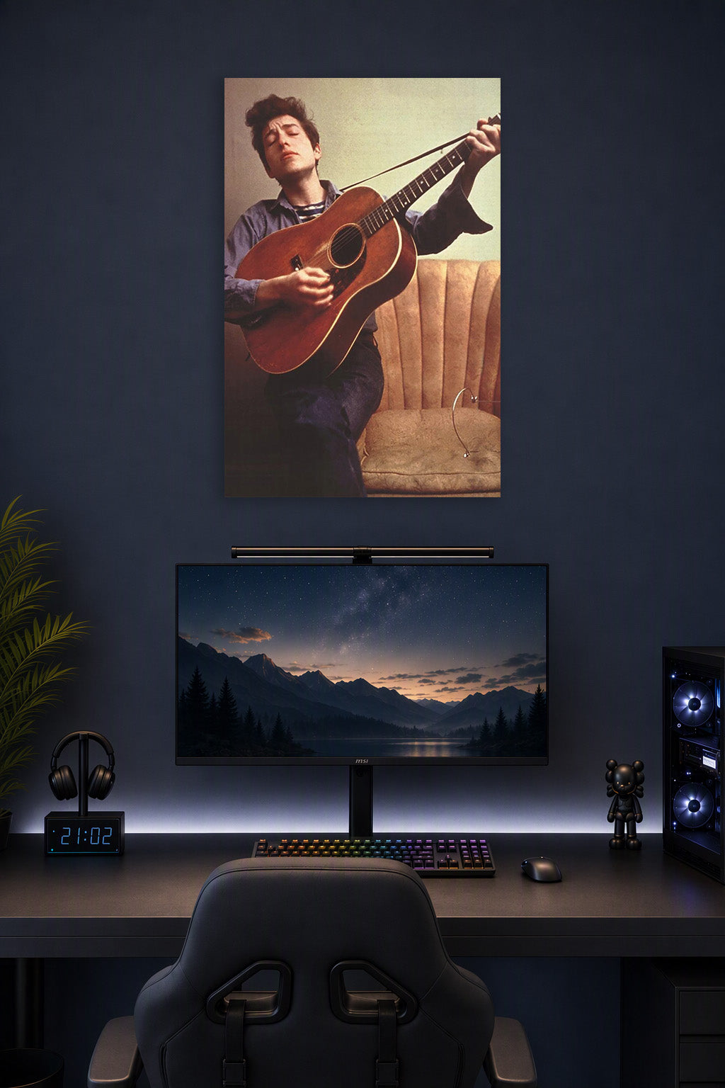 Bob Dylan in a gaming desk setup above a monitor.